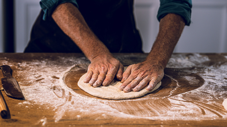 Hands kneading pizza dough