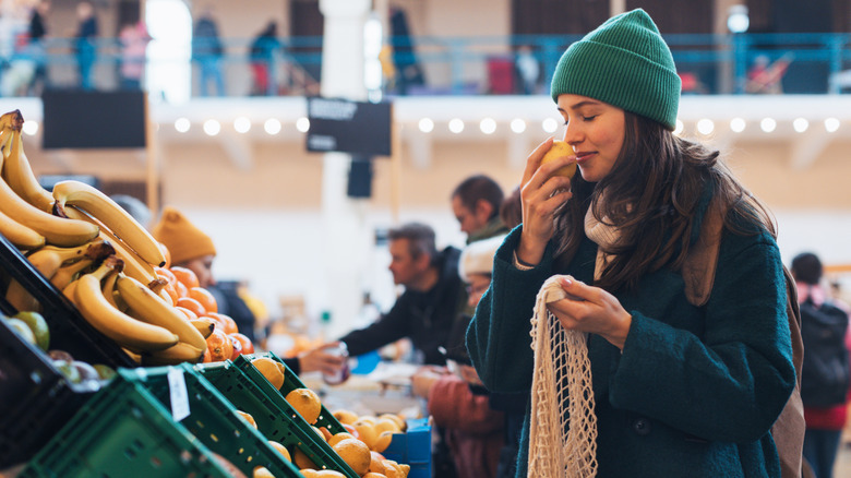 Woman smelling a lemon at the store