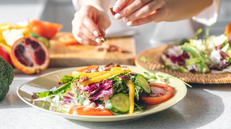 Person making salad in a plate