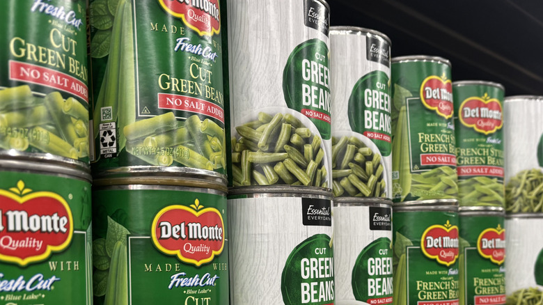 Cans of vegetables on a store shelf.