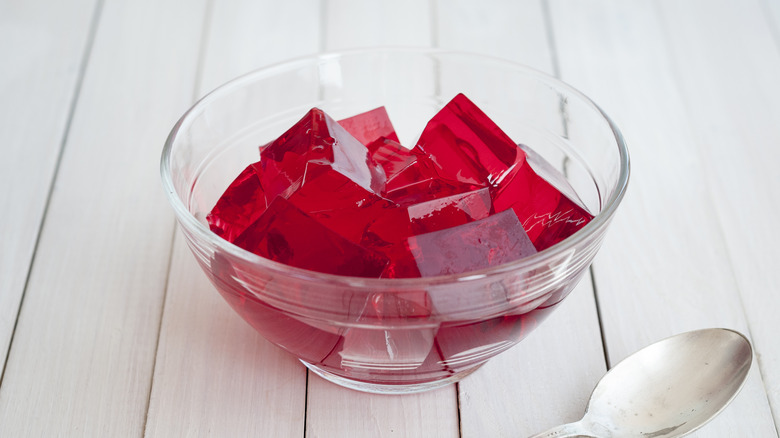 A clear bowl filled with cubes of red jello