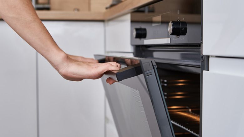 A woman opening an oven