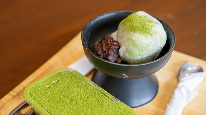 A dish of ice cream has been sprinkled with matcha powder.