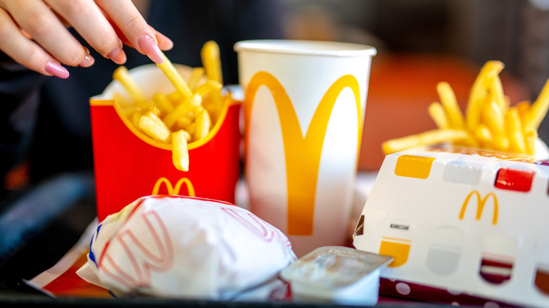 Several food from Mcdonald's on a tray, including fries, and burgers hidden inside their containers.