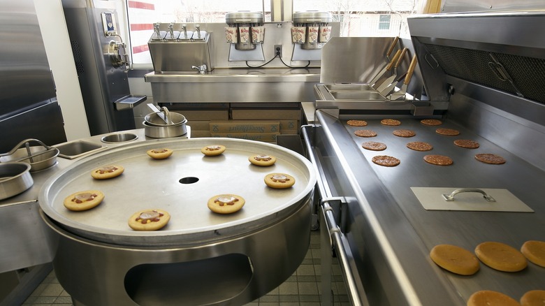 A look inside a McDonald's kitchen with burger buns and patties cooking
