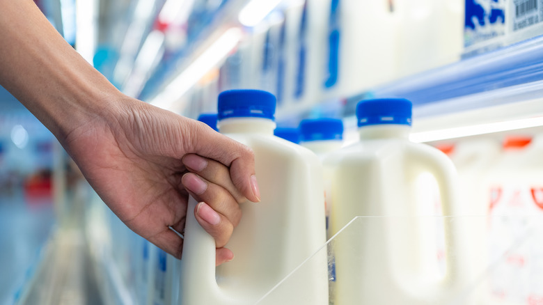 Hand grabbing carton of milk