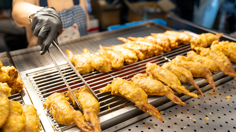 a cook grilling chicken wings