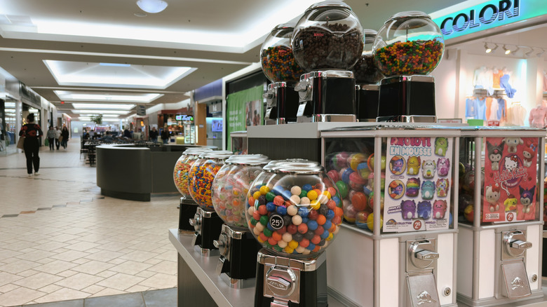 Gumball machine station at the mall with multiple machines stocked with gum, candy, and toys.