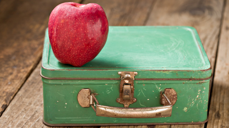 Old school metal lunch box and apple on top