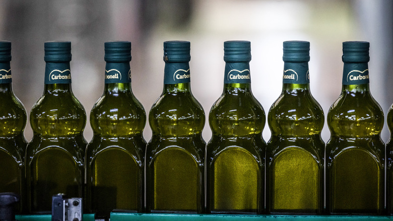 line of green bottles of olive oil