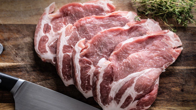 Fresh raw pork steaks on a wooden board