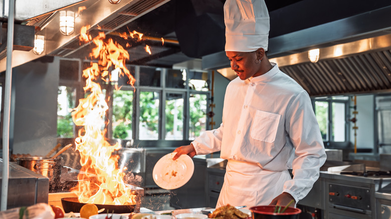 Chef cooking with fire in a professional kitchen