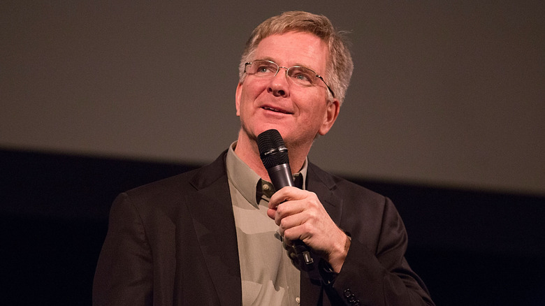 Rick Steves smiles with a microphone in his hand