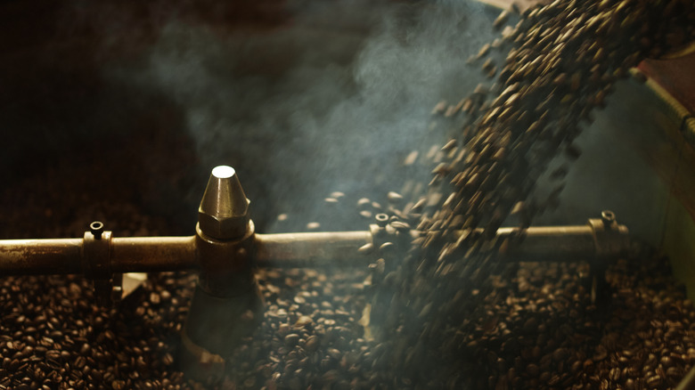 Coffee beans being poured into a coffee roaster