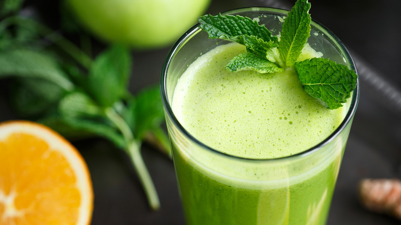 Fresh-pressed green juice in a glass with mint garnish