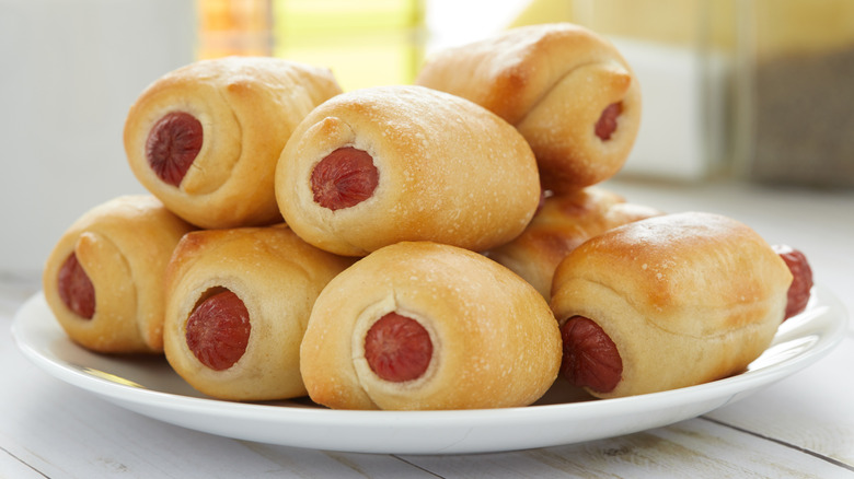 a plate of pigs in a blanket (hot dogs wrapped in dough)