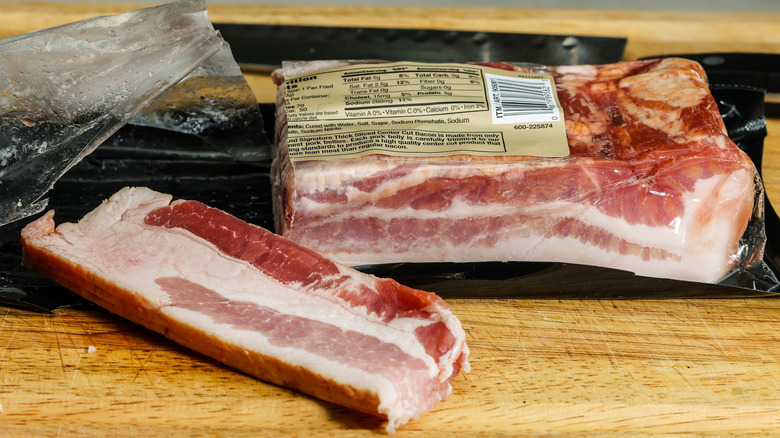 A piece of pork belly with an injection needle going into it.