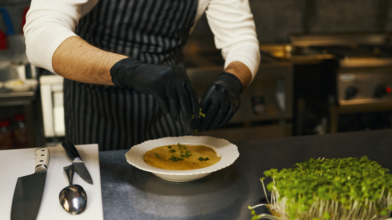 Chef plating soup at restaurant