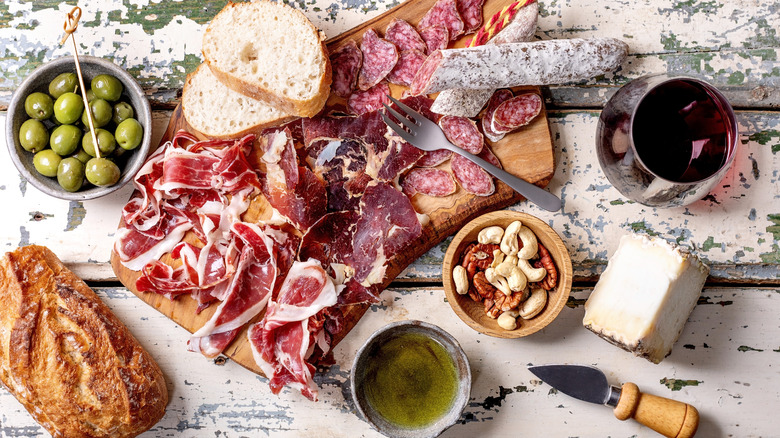 savory charcuterie board elements, including ham, olives, cheese, and nuts