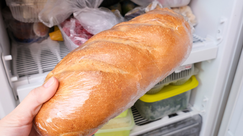 hand putting bread in fridge