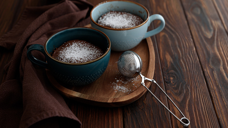 two mug cakes dusted in powdered sugar