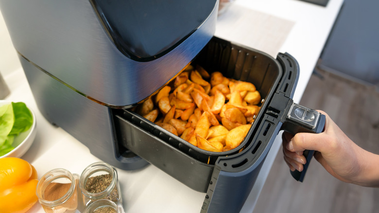 Air fryer machine in the kitchen. Baked potatoes.