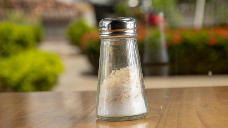 Salt shaker with grains of rice inside.