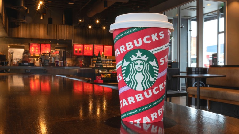 A red Starbucks holiday cup is seen in close-up at a Starbucks location.