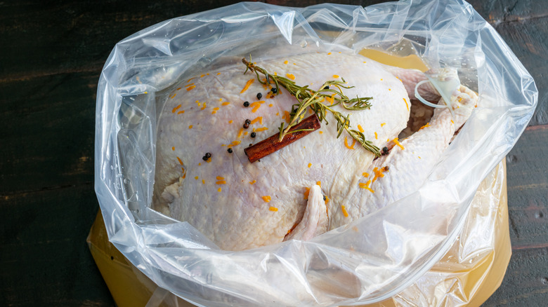 turkey, seasonings, and brine in a plastic bag
