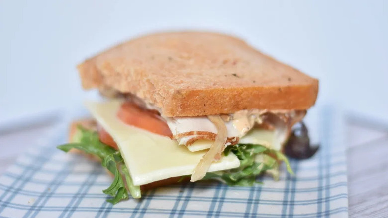 a Panera bacon turkey bravo sandwich on a checkered blue plate