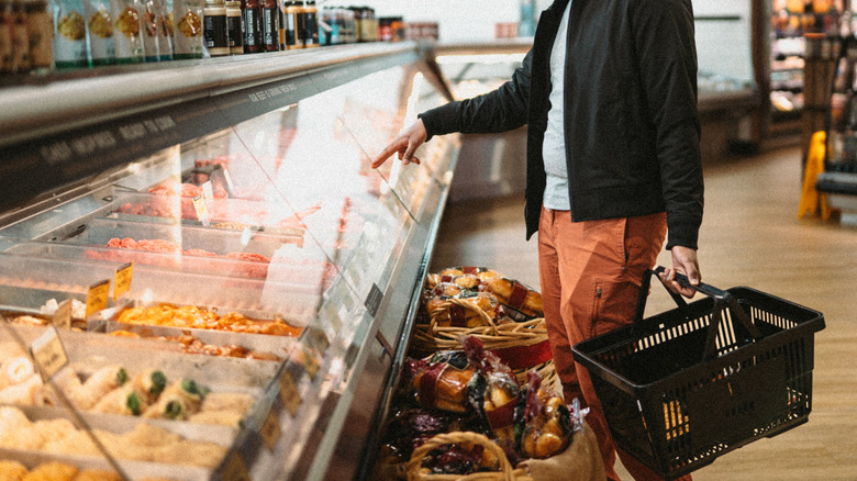 Person pointing to an item at a deli