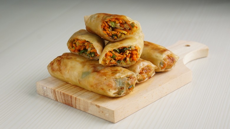 A stack of lumpia on a cutting board