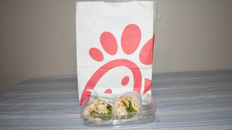 Chick Fil-A's Cool Wrap in a to-go container in front of a branded Chick fil-A bag