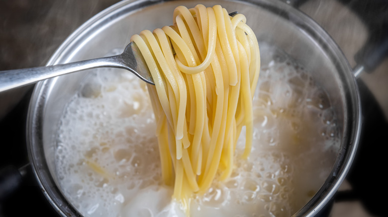 Spaghetti on fork over pot