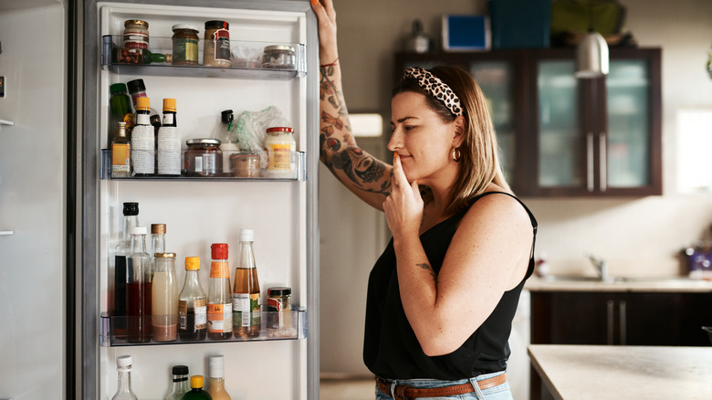 Woman looking inside a refrigerator