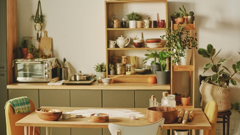 Cluttered kitchen with various kitchen essentials on display on shelf risers.