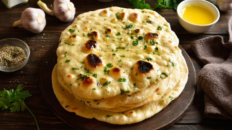 flat loaves of naan on a wooden cutting board