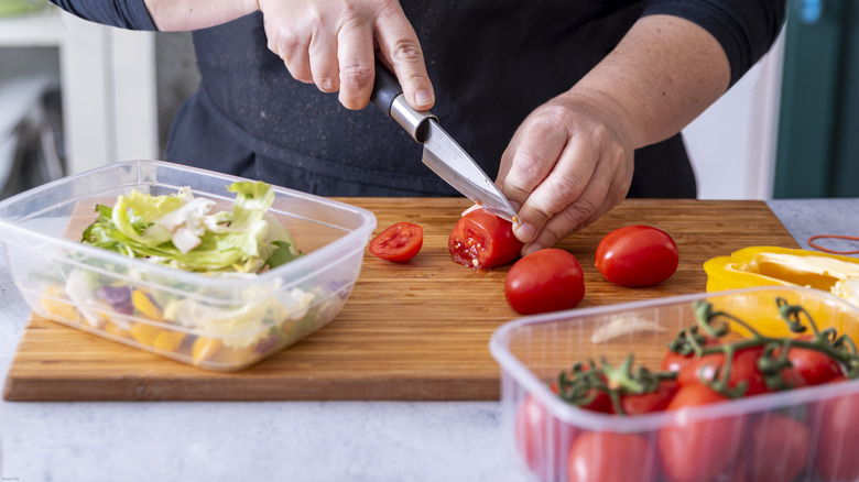 Person filling plastic food containers