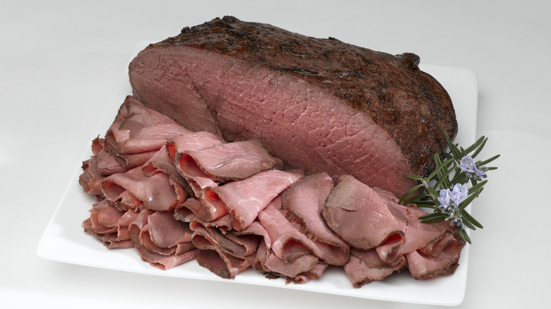 A deli worker slicing meat