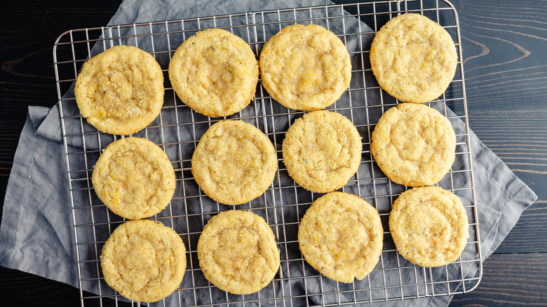 A metal cooling rack full of fresh, chewy sugar cookies.