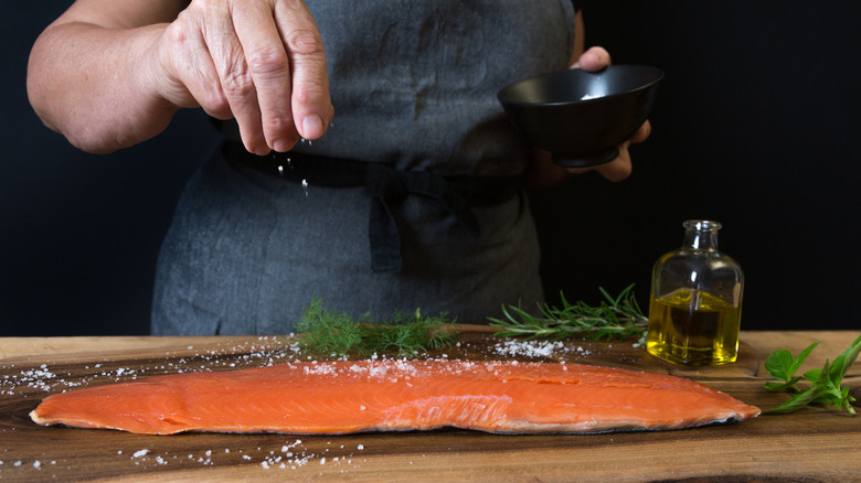 Person seasoning salmon filet