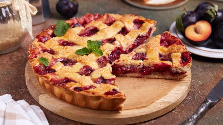 A whole berry pie with a slice taken out.