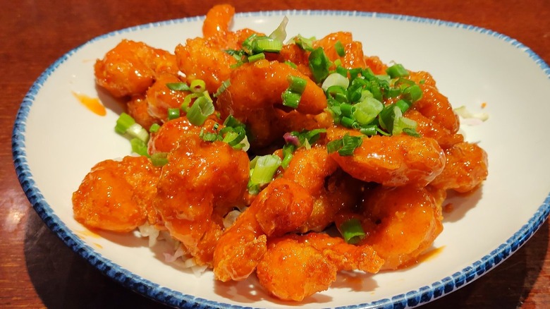 Red Lobster's crispy dragon shrimp appetizer, garnished with green onions, served on a white, blue-trimmed plate
