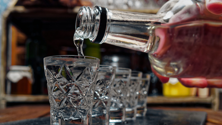 Hand pouring vodka shots