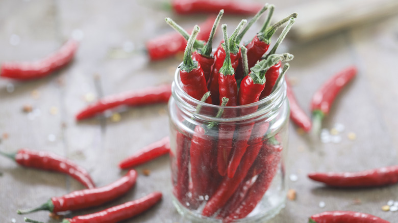 A glass jar stuffed with hot red peppers