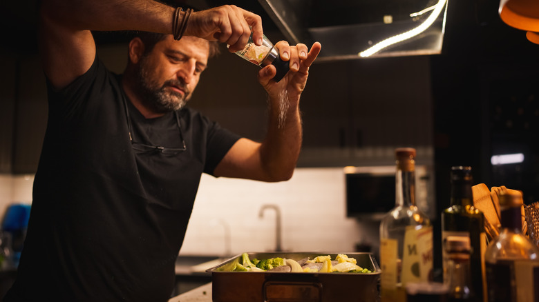 Man seasoning food from above
