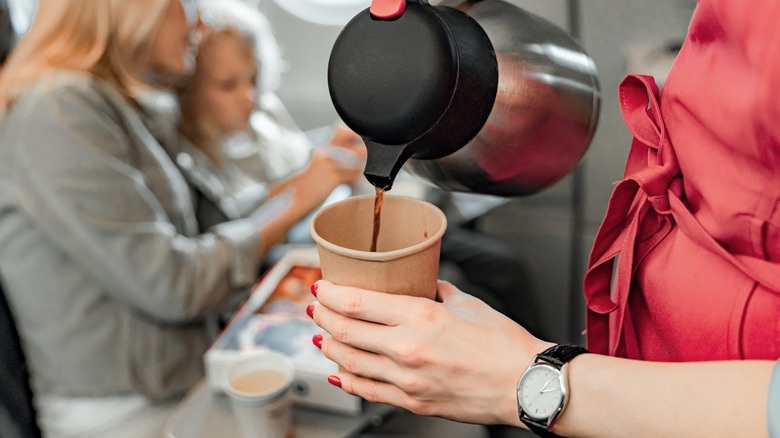 Flight attendant pouring coffee