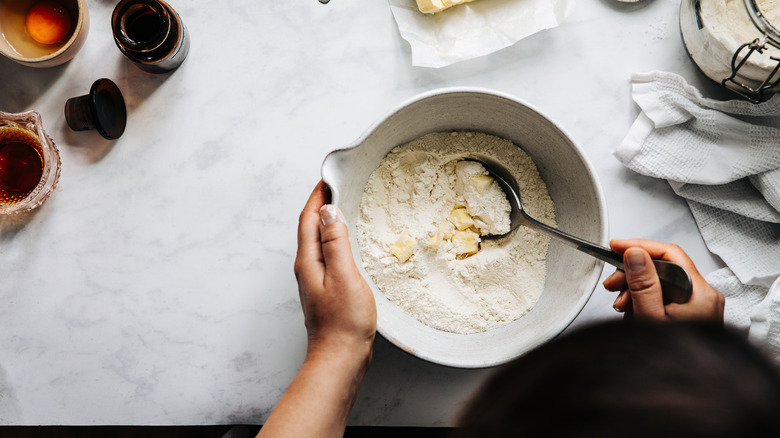 person with bowl of baking ingredients