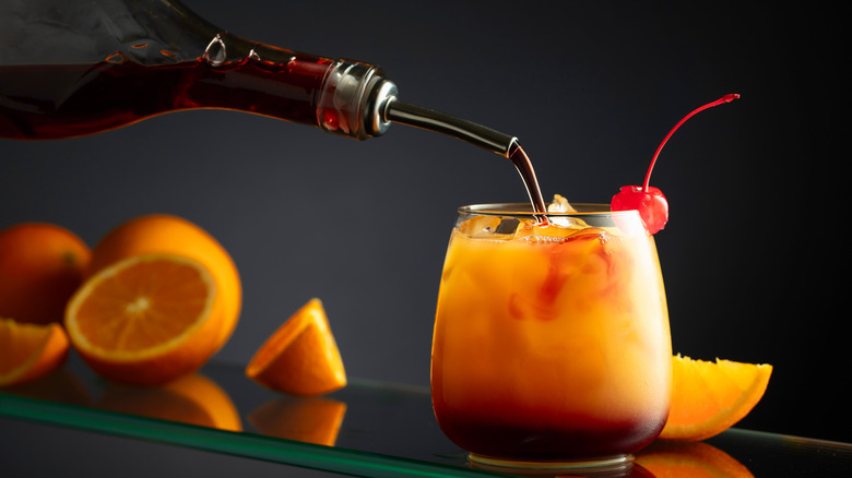 Adding homemade grenadine to a tequila sunrise