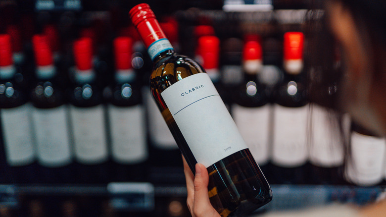 Holding bottle of wine